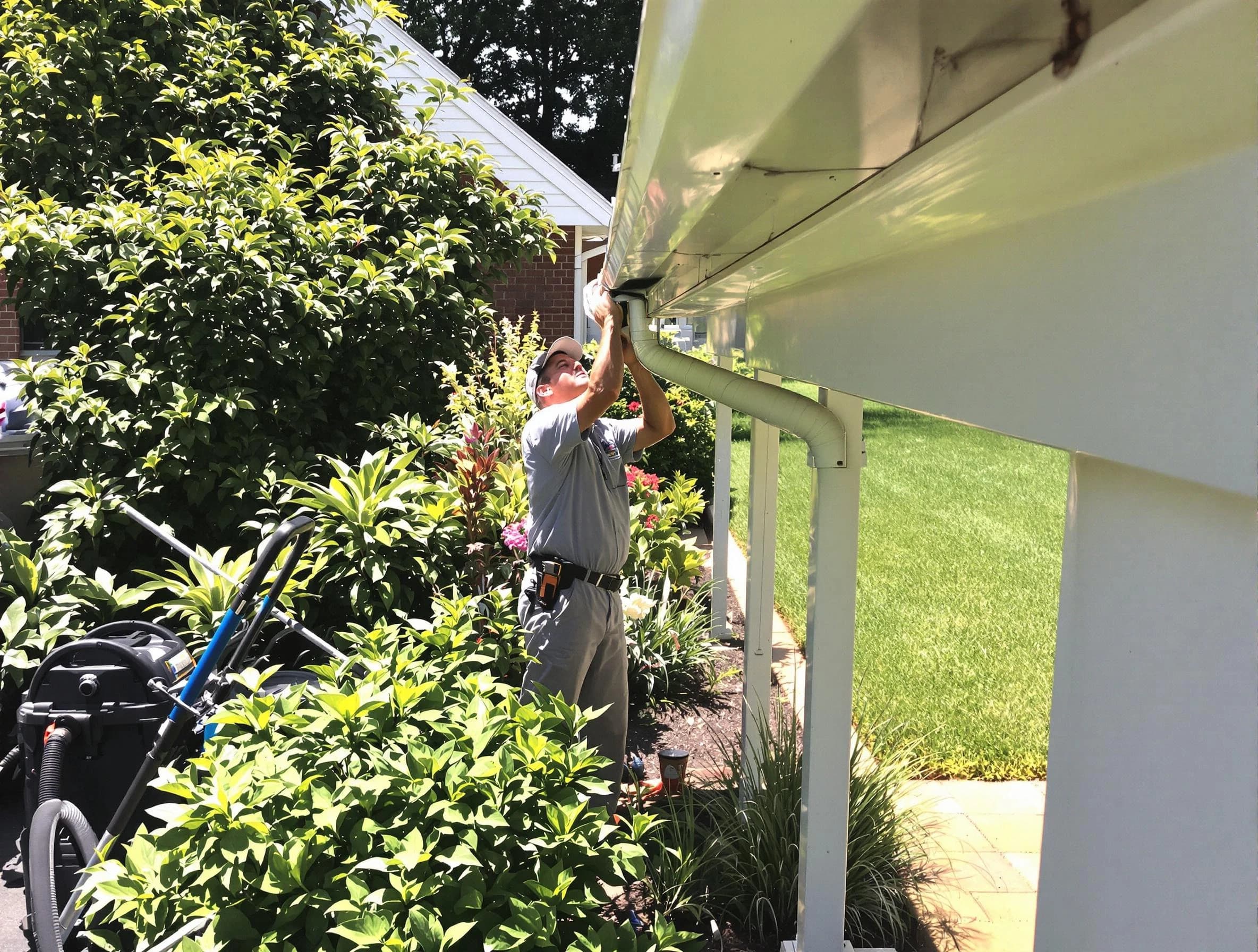 Technician flushing a blockage from a downspout in Warrensville Heights, OH